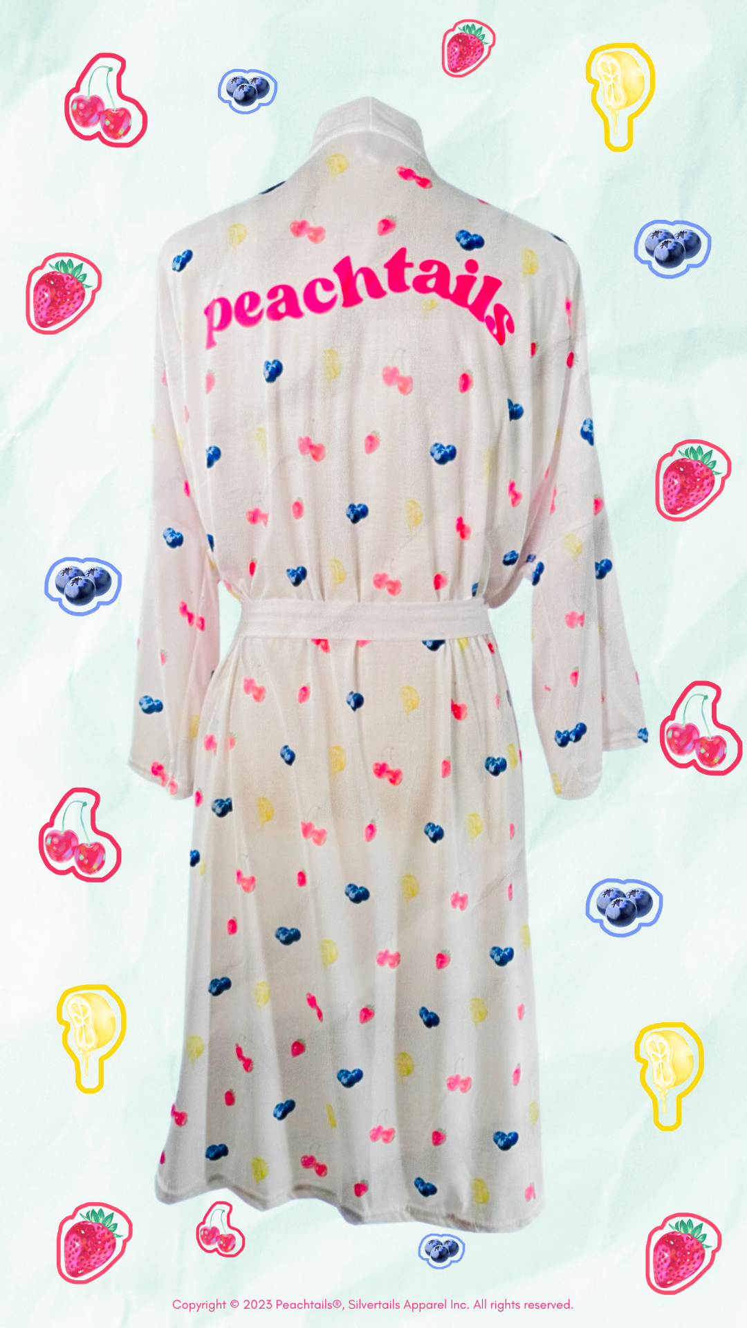 The image features a light-colored bathrobe with a fruit and ice pop pattern displayed on a patterned background. The name "peachtails" is printed across the back in bold, pink, cursive letters. Surrounding the robe are playful drawings of various fruits and ice pops in bright, cheerful colors. The design suggests a fun, casual style, and the robe appears soft and comfortable. A copyright statement at the bottom attributes the design to Peachtails© and Silverlakits Apparel Inc.